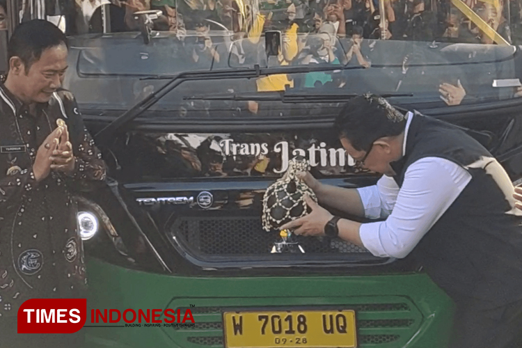 Pj Gubernur Jatim Adhy Karyono menjatuhkan kendi sebagai tanda launching Bus Transjatim Koridor IV di depan Pendopo Lokatantra Lamongan, Jumat (9/8/2024). (Foto: Moch. Nuril huda/TIMES Indonesia)