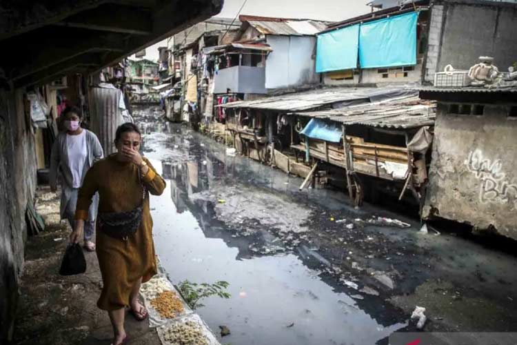 Dua warga melintas di kawasan rumah padat penduduk Kebon Melati, Jakarta, Kamis (23/6/2022). (Foto: ANTARA FOTO/Rivan Awal Lingga)