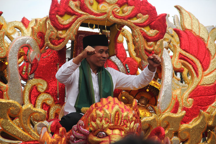 Paslon Bupati dan Wakil Bupati Bandung Barat, Edi Rusyandi dan Unjang Asari tunggangi ogoh-ogoh raksasa saat daftar ke KPU KBB. (Foto: Deni Supriatna/TIMES Indonesia)