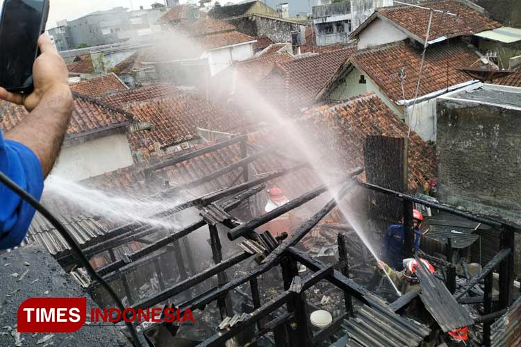 Petugas pemadam kebakaran saat melakukan pendidingan pada rumah yang terbakar di Kampung Empang Wetan, Empangsari, Tawang Kota Tasikmalaya, Senin (9/9/2024). (Foto: Harniwan Obech/TIMES Insonesia)