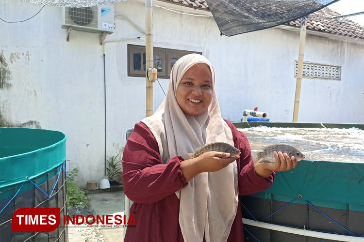 Fakhriyya saat menunjukkan ikan nila budidayanya (FOTO: Ikromil Aufa/ TIMES Indonesia)
