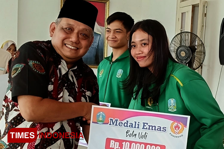 Pjs Bupati Ponorogo Joko Irianto menyerahkan bonus kepada Silva Rosanda atlet bola voli yang berhasil merebut medali emas bersama tim voli puti Jawa Timur. (Foto:Marhaban/TIMES Indonesia)