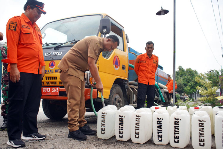 Pjs Bupati Kediri saat mengisi air bersih di galon air untuk warga (Foto: Diskominfo Kabupaten Kediri)