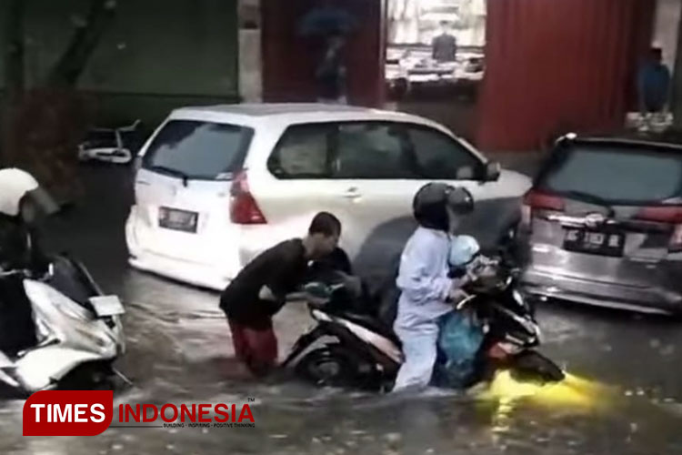 Sejumlah kendaraan roda dua mogok akibat terjebak banjir dan harus didorong (Foto: Canda Adisurya/TIMES Indonesia)