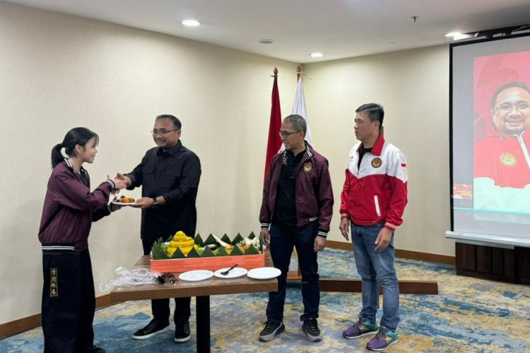 Ketua Umum PB Federasi Wing Chun Indonesia Yaqut Cholil Qoumas menyerahkan potongan tumpeng pada seorang atlet peraih juara dunia sebagai bentuk syukur atas prestasi yang diraih, di Jakarta, Sabtu (16/11/2024). (FOTO: ist)