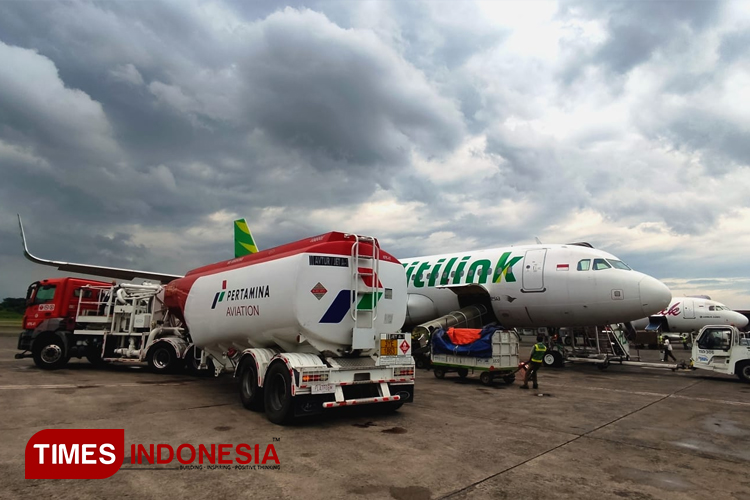 Truk pertamina melakukan pengisian bahan bakar untuk Pesawat Citilink di Bandara Abdulrahman Saleh dengan latar belakang awan mendung. (FOTO : Adhitya Hendra/TIMES Indonesia)