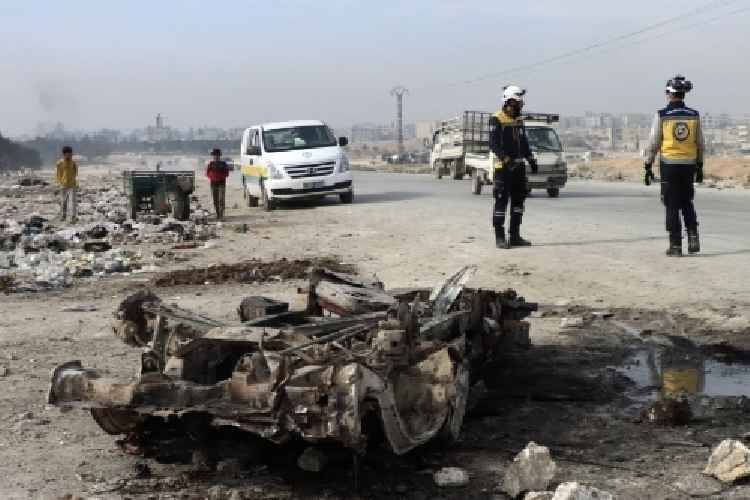 Petugas White Helmets sedang memeriksa bangkai mobil yang meledak dan menewaskan 15 wanita pekerja pertanian di Suriah. (Foto: AP)