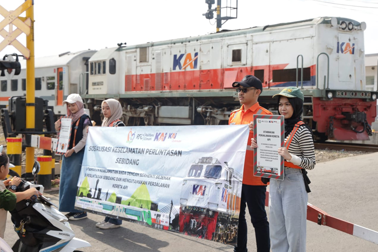 Sejumlah pecinta kereta api dan petugas PT. KAI, membentangkan poster imbauan keselamatan KA di wilayah Daop 2 Bandung, Senin (10/2/2025) (FOTO: Humas Daop 2 Bandung/TIMES Indonesia)