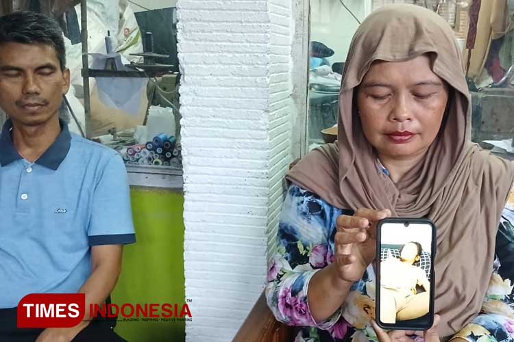 Lia didampingi suaminya menunjukan foto saat putrinya di rawat di PMC karena DBD. (Foto: Susi/TIMES Indonesia)