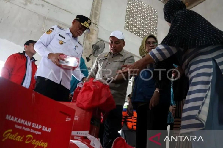 Pj Gubernur Sulawesi Selatan Fadjry Djufry (kiri) menyerahkan bantuan kepada warga terdampak saat meninjau kondisi banjir di Perumnas Antang, Makassar, Sulawesi Selatan, Rabu (12/2/2025). (FOTO: ANTARA FOTO/Arnas Padda/foc.)