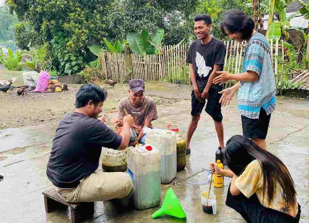 Mahasiswa Unitri Malang mengajarkan pada petani Desa Tulungrejo, Ngantang, mengubah limbah jadi pupuk cair. (Foto: TI PHOTO NETWORK)