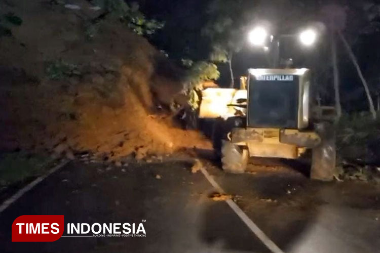 Alat berat UPT PJJ Pacitan membersihkan material tanah longsor yang menutup jalan di Desa Gedangan, Tegalombo. (Foto: Yusuf Arifai/TIMES Indonesia)