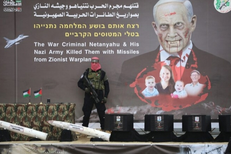 Empat peti mati yang berisi empat jenasah sandera saat dipersiapkan di atas panggung dengan backdrop Benjamin Netanyahu digambarkan Sebagai drakula. (FOTO: Al Jazeera)