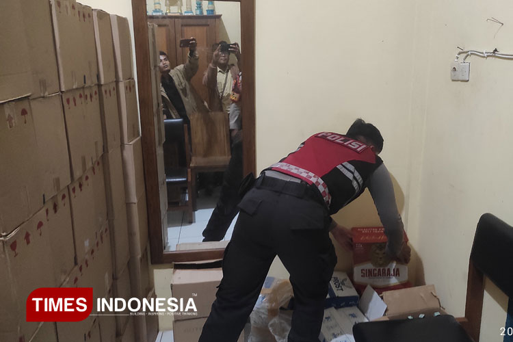 Salah satu anggota Polres Situbondo Menunjukkan hasil Sitaan Miras, Kamis, 27/2/2025. (Foto: Rifa'i/TIMES Indonesia)