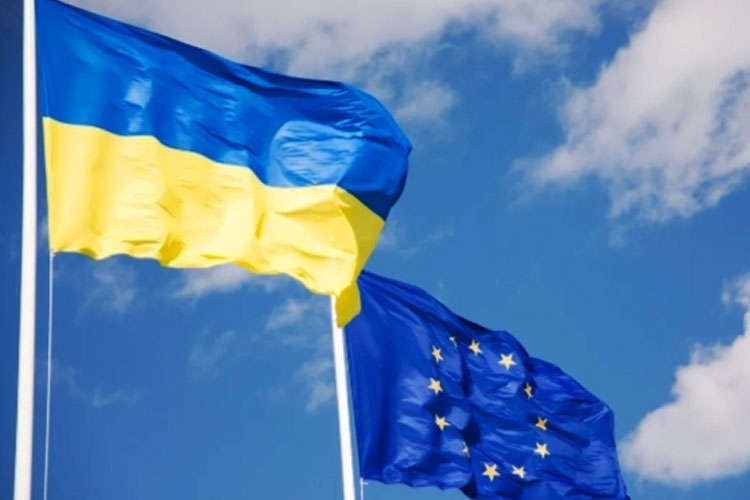 Bendera Ukraina dan Uni Eropa (UE) berkibar dengan langit biru di latar belakang. (FOTO A: Kyiv Independent/Getty Images)