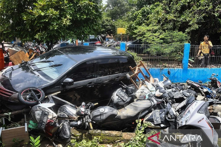 Warga wilayah Perumahan Pondok Gede Permai, Jatiasih Bekasi mengamati mobil dan sepeda motor yang berserakan setelah tersapu banjir, Selasa (4/3/2025). Rabu (5/3/2025) hari ini, banjir di wilayah tersebut mulai surut. (foto: Fakhri Hermansyah/ANTARA)
