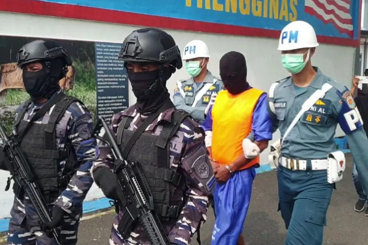 Personel TNI AL bersenjata lengkap menggiring tersangka jaringan narkoba internasional usai konferensi pers di Mako Lanal Lhokseumawe, Paloh Iqeuh, Kecamatan Dewantara, Aceh Utara, Kamis(6/3/2025). (ANTARA/HO-TNI AL Lanal Lhokseumawe)