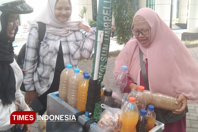 Kebahagiaan sederhana daro sosok Suratmi saat membuatkan pesanan jamu untuk pelanggannya (FOTO: Vania K Hidayat/TIMES Indonesia)