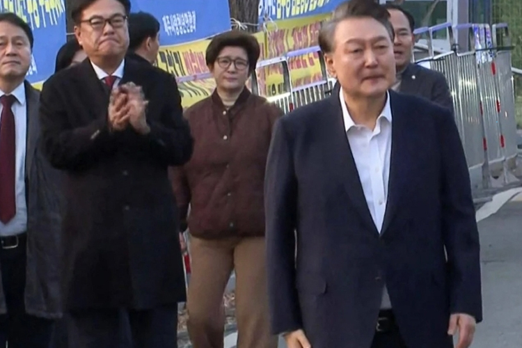 Presiden Korea Selatan yang dimakzulkan Yoon Suk-yeol (kanan) berjalan keluar dari Pusat Penahanan Seoul di Uiwang setelah dibebaskan pada hari Sabtu. (FOTO: South China Morning/AFP)