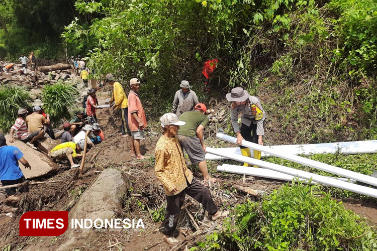 Warga bersama Polri saat membersihkan material banjir dan memperbaiki pipa rusak akibat banjir (FOTO: Moh Bahri/TIMES Indonesia)