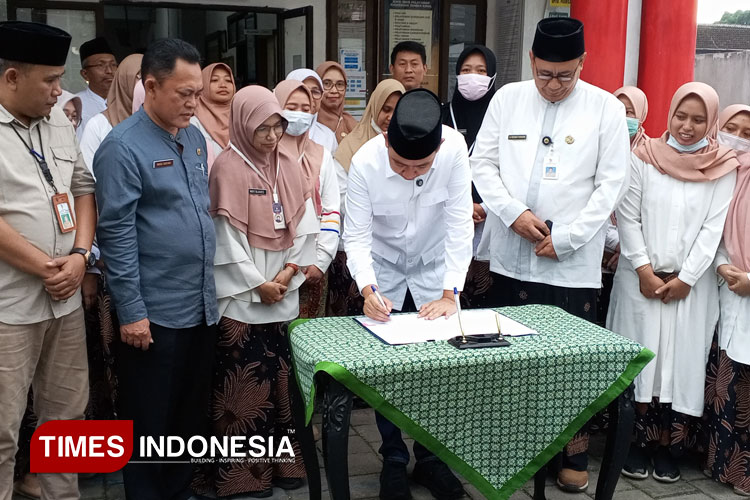 Bupati Jember Muhammad Fawait didampingi camat dan lurah serta tenaga kesehatan saat tandatangani kebijakan lima hari kerja di puskesmas Jember kidul, kecamatan kaliwates. (M. ABDUL BASID / TIMES Indonesia)