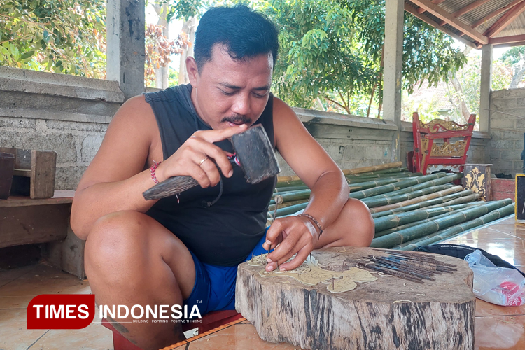 Kayan Eka Mahardika sedang mengukir diatas karton untuk hiasan ogoh-ogoh saat perayaan Hari Raya Nyepi di Desa Patoman, Kecamatan Blimbingsari, Banyuwangi. (Foto : Anggara Cahya/TIMES Indonesia)