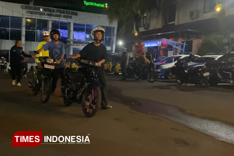 Para pengendara saat mendorong motornya masuk Mapolresta Malang Kota. (Foto: Rizky Kurniawan Pratama/TIMES Indonesia)