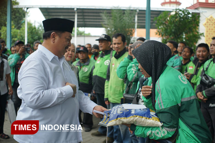 Warsubi saat menyalurkan sedekah dan zakat kepada ratusan Ojol di halaman rumahnya di Desa Mojokrapak, Tembelang, Jombang, Minggu (16/3/2025). (FOTO: Rohmadi/TIMES Indonesia)