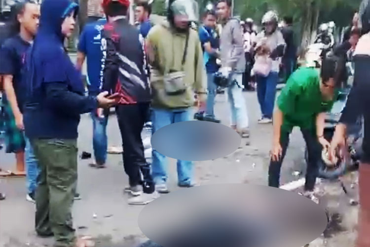 Tampak dua korban terlibat kecelakaan tergelak di jalan dan dikerumuni pengedara lain (FOTO: Tangkapan layar video)