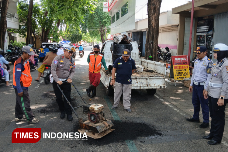 Petugas lantas kepolisian di Banyuwangi sedang memperbaiki aspal jalan untuk meminimalisir laka lantas ketika menghadapi arus mudik. (Foto : Anggara Cahya/TIMES Indonesia)