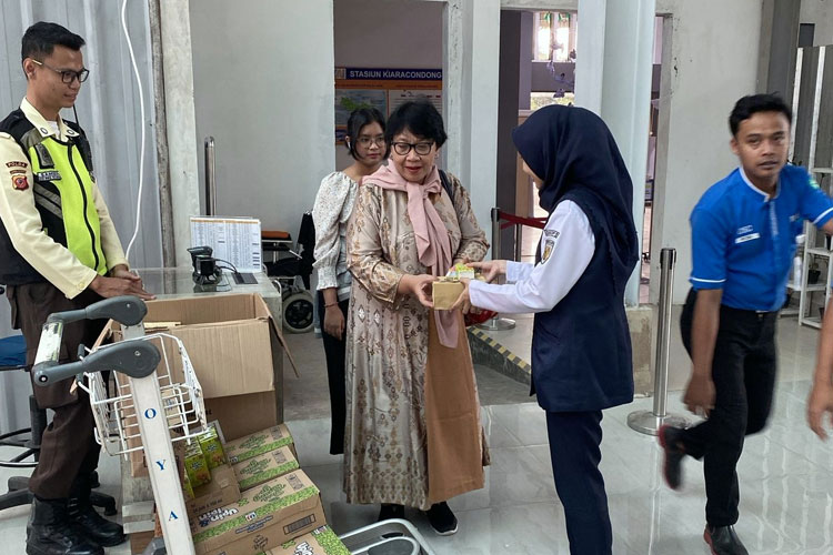 Seorang petugas PT KAI saat memberikan bingkisan takjil kepada salah satu penumpang di Stasiun Bandung, Sabtu (22/3/2025) (FOTO: Humas Daop 2 Bandung)
