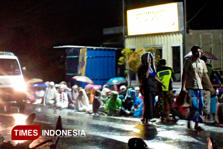 Tampak jemaah salat Tarawih hingga tepi jalan raya, dalam keadaan basah akibat hujan, mengikuti tarawih yang dipusatkan di Masjid Al Ilyas Desa Gondanglegi Kulon, Kabupaten Malang, Sabtu (22/3/2025) malam. (Foto: Amin/TIMES Indonesia)