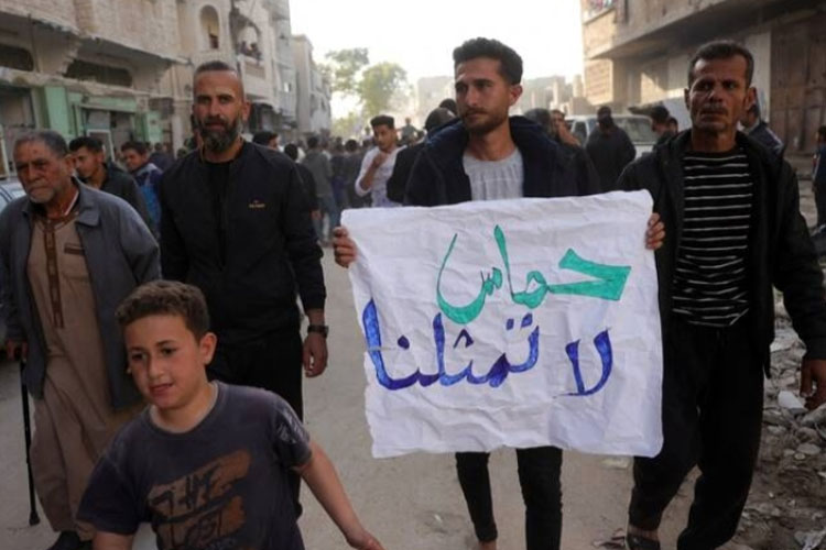 Seorang pemuda Palestina membawa spanduk bertuliskan dalam bahasa Arab,