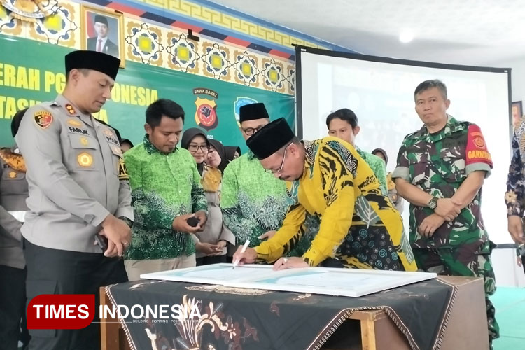 Ketua PGM Kota Tasikmalaya Asep Rizal dan Kapolres Tasikmalaya Kota AKBP M. Faruk Rozi saat menandatangani naskah kerja sama Polwan Mengajar di Madrasah di Kampus IAIT, Sabtu (12/4/2025) (FOTO: Harniwan Obech/TIMES Indonesia)