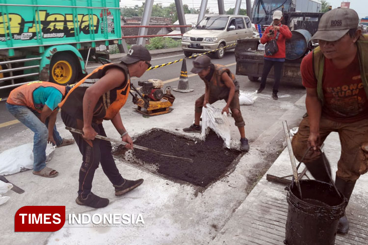 Petugas memberi lapisan aspal pada Jembatan Pajarakan Probolinggo yang rusak (Foto: Fafa Harowy/TIMES Indonesia)