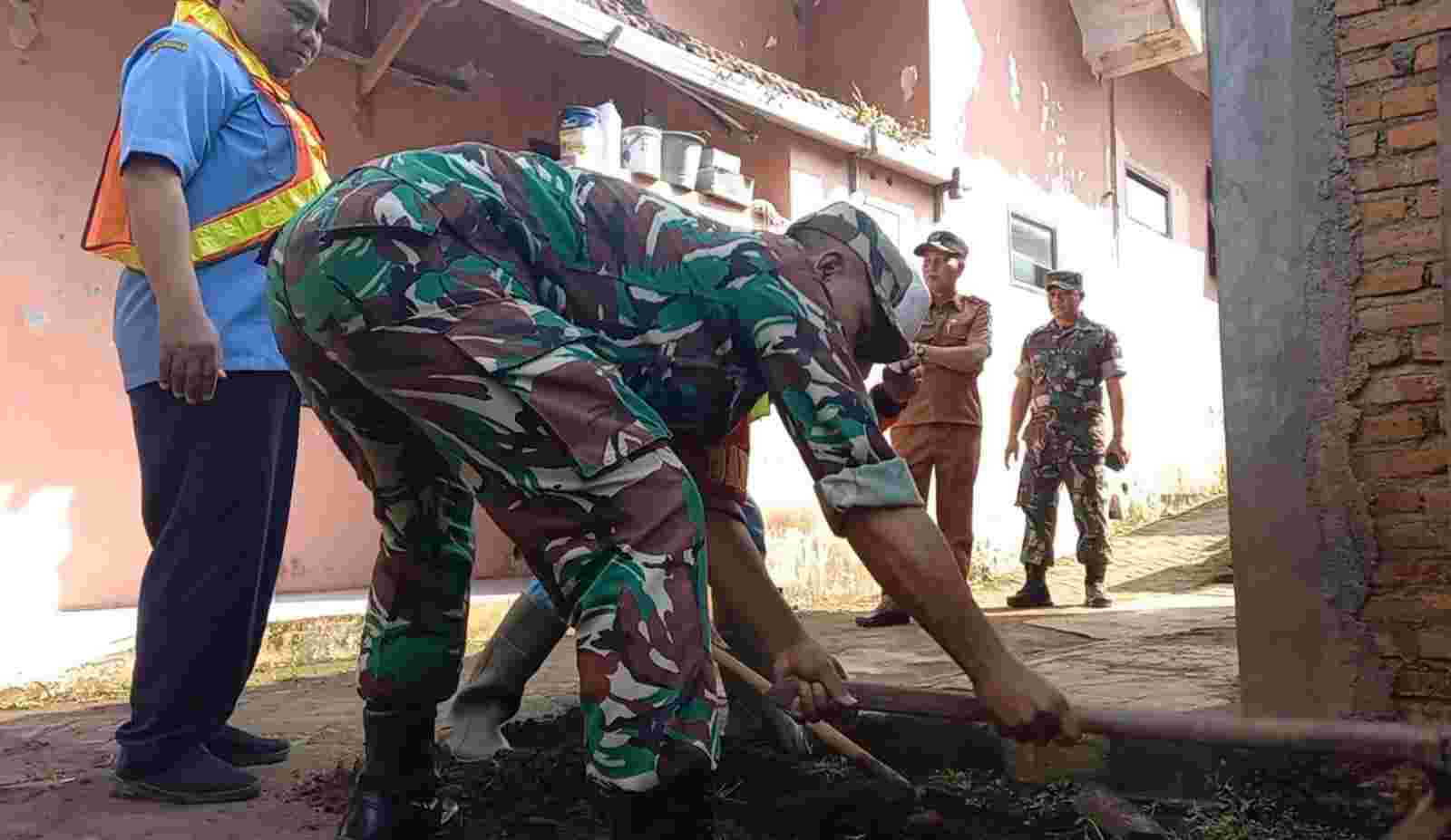 Aparat Koramil Tajinan membantu pemasangan PDAM ke rumah warga. (Foto: Koramil Tajinan for TI)