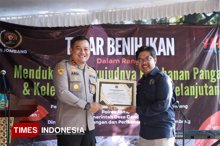 Ketua PWI Jombang Muhammad Mufid saat menyerahkan penghargaan kepada Kapolres Jombang AKBP Ardi Kurniawan pada rangkaian Hari Pers Nasional 2025. (FOTO: Rohmadi/TIMES Indonesia)