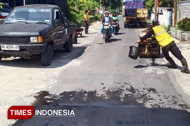 Petugas Dinas Pekerjaan Umum, Perumahan dan Kawasan Permukiman (DPUPKP) Sleman saat melakukan perbaikan jalan kabupaten pada awal Mei 2025. (Foto: Tulung/TIMES Indonesia)