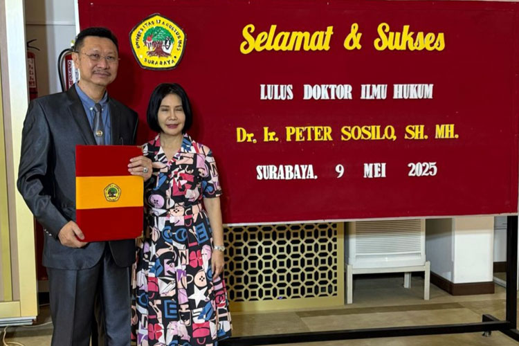 Peter Sosilo bersama istri usai menjalani sidang terbuka promosi doktor yang berlangsung di Gedung R Ing Soekonjono, Universitas 17 Agustus 1945 Surabaya, Jumat (9/5/2025). (Foto: Dok.Pribadi)