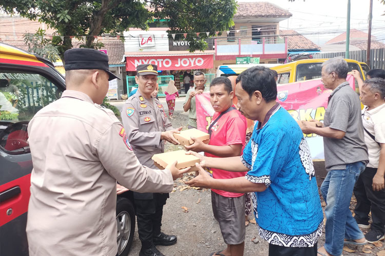Petugas kepolisian tengah membagikan rezeki berupa nasi kotak pada masyarakat. (Foto : Polresta Banyuwangi For TIMES Indonesia)