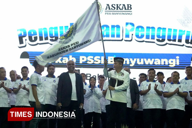 Ketua Askab PSSI Banyuwangi, Michael Edy Hariyanto, SH, MH, mengibarkan bendera Askab PSSI Banyuwangi. (Foto: Fazar Dimas/TIMES Indonesia)