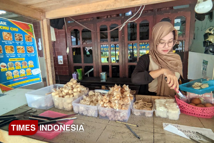 Chuchu Siti Masithoh, pemilik Seblak Teh Chu Chu, sedang melayani pelanggan di kedainya yang berkonsep prasmanan di kawasan Ploso, Pacitan. (FOTO: Yusuf Arifai/TIMES Indonesia)