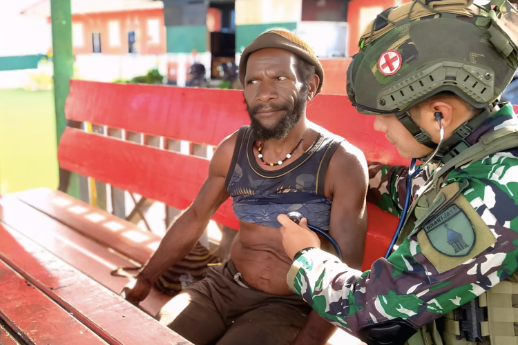 Dokter militer Lettu Ckm Indra Sitepu saat memeriksa kesehatan Kepala Suku Beoga di Pedalaman Papua.(FOTO : Dok Satgas Pamtas RI-PNG Mobile Yonif 500/Sikatan for Times Indonesia)