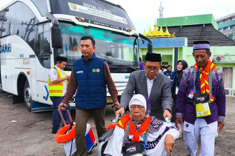 Deputi Koordinasi Pelayanan Haji (BPH) Puji Raharjo membantu mendorong kursi roda salah seorang calon haji menuju bis untuk berangkat ke Tanah Suci menjalankan ibadah haji di Bandarlampung, Senin (12/5/2025). (FOTO: ANTARA/Dian Hadiyatna)
