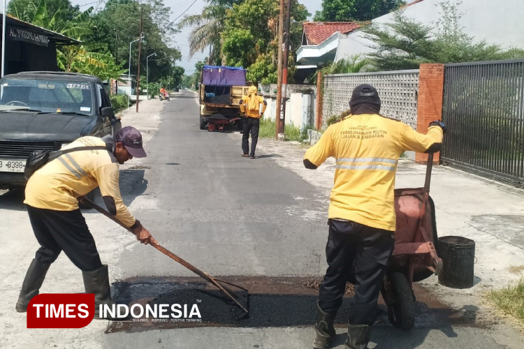 Para pekerja dari Dinas PUPKP Pemerintah Kabupaten Sleman sedang melakukan perbaikan jalan. (FOTO: A Riyadi/TIMES Indonesia)