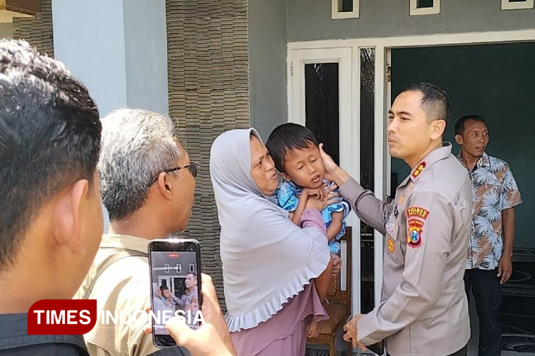 Kapolres Pacitan, AKBP Ayub Diponegoro Azhar saat menyambangi bocah yang menderita hidrosefalus di Sudimoro. (Foto: Yusuf Arifai/TIMES Indonesia)