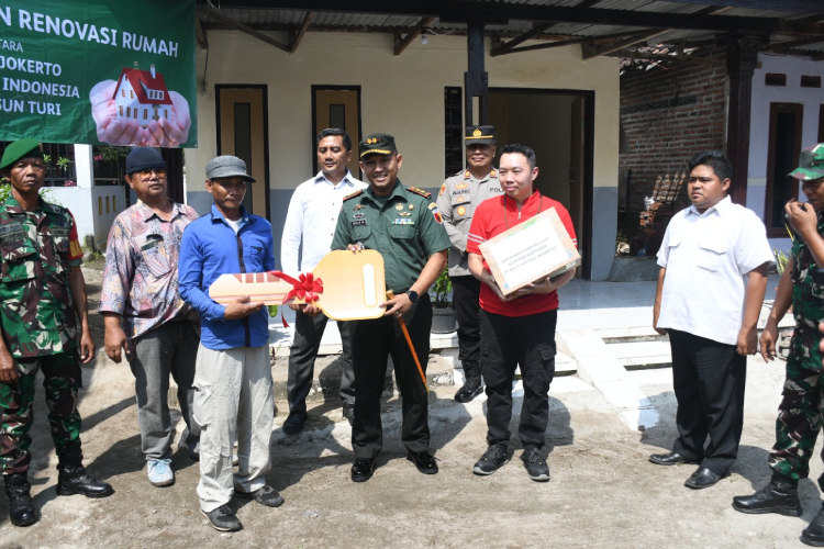 Dandim 0815/Mojokerto Letkol Inf Rully Noriza saat menyerahkan kunci rumah kepada Wiwid Hariyono warga Dusun Turi, Desa Sampangagung, Kecamatan Kutorejo, Kabupaten Mojokerto. (FOTO: Pendim Mojokerto for Times Indonesia)