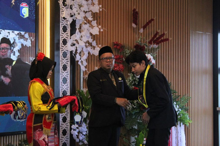 Drs. Parngadi, M. Pd, Kepala SMP Muhamadiyah 9 Gondanglegi Kabupaten Malang saat memberikan ucapan selamat kepada sala satu siswanya Aryasatya Panji Prasista.