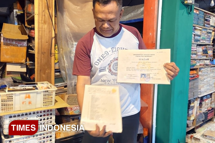 Penjual buku lama di Pasar Buku Velodrome Malang, Galih Nur Bagyo saat menunjukkan salah satu koleksinya berupa skripsi UGM keluaran tahun 1983. (Foto: Achmad Fikyansyah/TIMES Indonesia)