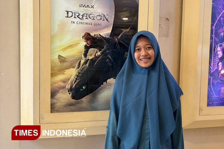 Nada berswafoto di depan poster How to Train Your Dragon 2025 (14/56/2025). (Foto: Khodijah Siti/TIMES Indonesia)